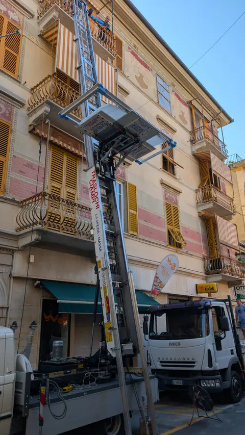 Autoscala Ciampi in azione per l'elevazione di infissi e serramenti su edificio residenziale a La Spezia